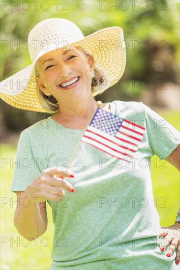 Portrait of woman holding american flag.
Photo : Daniel Grill