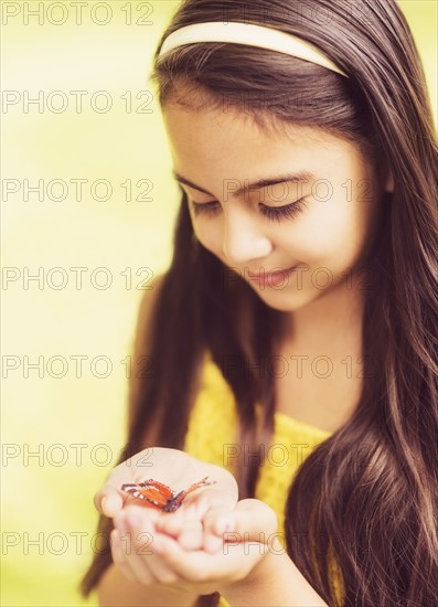 girl ( 8-9) holding butterfly in hands.
Photo : Daniel Grill