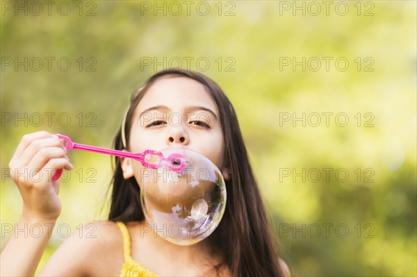 Portrait of girl (8-9) blowing bubbles.
Photo : Daniel Grill