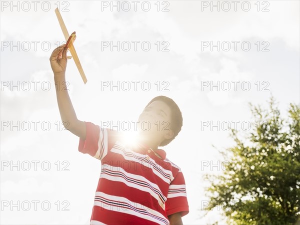 boy (6-7) playing with toy airplane.
Photo : Daniel Grill