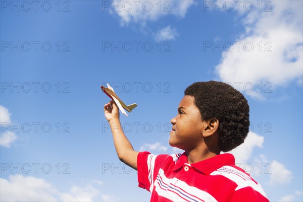 boy (6-7) playing with toy airplane.
Photo : Daniel Grill