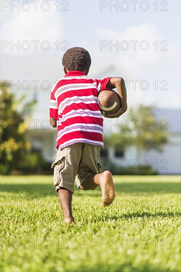 boy (6-7) playing football.
Photo : Daniel Grill