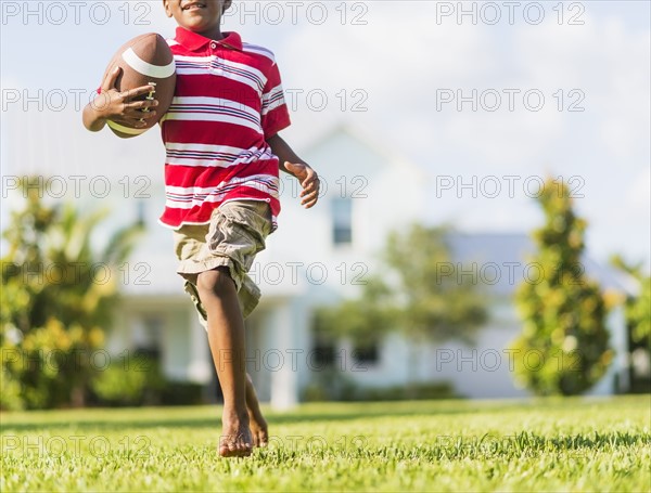 boy (6-7) playing football.
Photo : Daniel Grill