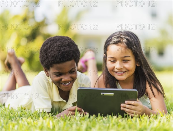 girl ( 8-9) and boy (6-7) using digital tablet.
Photo : Daniel Grill