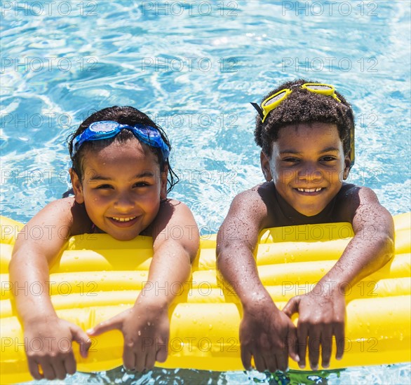 Portrait of kids( 6-7, 8-9) with pool raft.
Photo : Daniel Grill