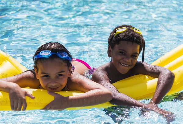 Portrait of kids( 6-7, 8-9) with pool raft.
Photo : Daniel Grill
