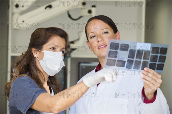 Dentist and assistant looking at x-ray.