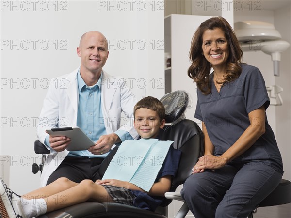 Portrait of dentist, patient( 12-13) and assistant.