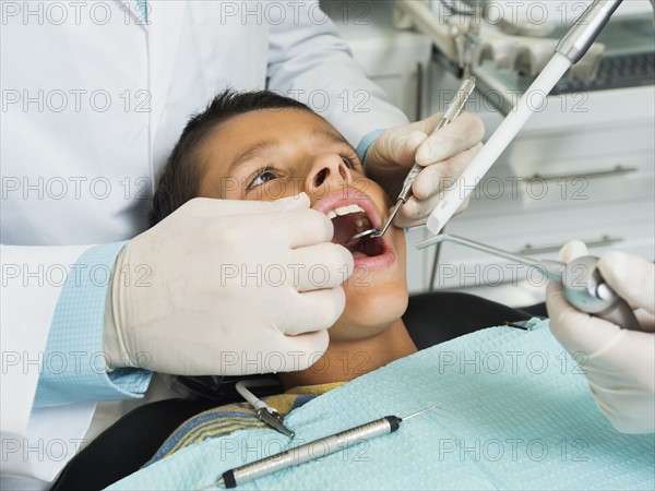 boy (10-11) being treated in dentist's office.