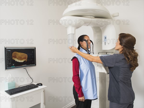 Assistant making x-ray image of patient teeth.