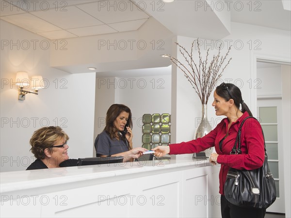 Female patient at doctor's office front desk.