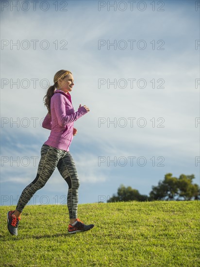 Woman running through lawn.