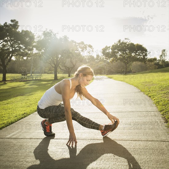 Woman stretching in park.