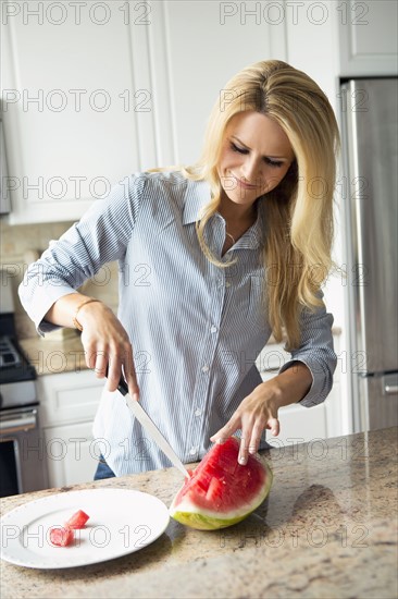 Blonde housewife cutting watermelon.
Photo : pauline st.denis