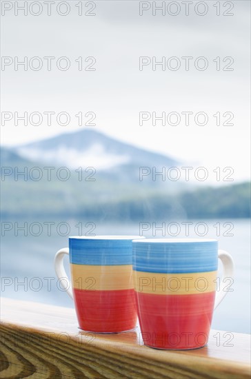 Coffee mugs on railing.
Photo : Tetra Images