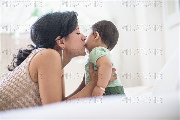 Mother kissing her baby son (6-11 months).