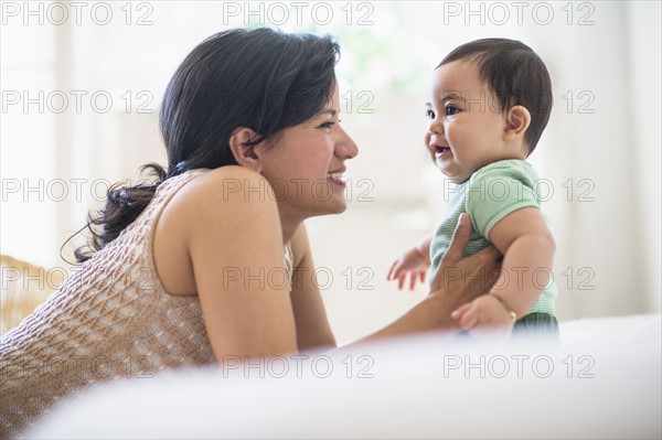 Mother with her baby son (6-11 months) in bedroom.