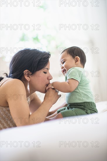 Mother kissing her baby son's hand (6-11 months).