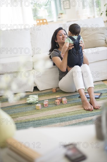 Mother playing with her son (6-11 months) in living room.