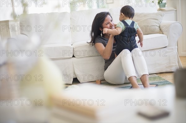 Mother playing with her son (6-11 months) in living room.