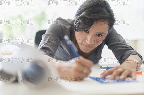 Woman drawing blueprints.