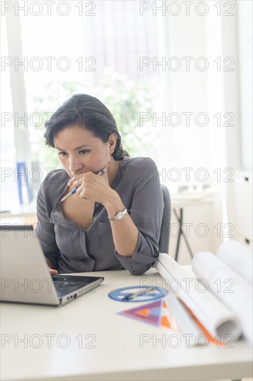 Female architect working with laptop.