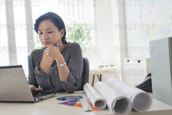 Female architect working with laptop.