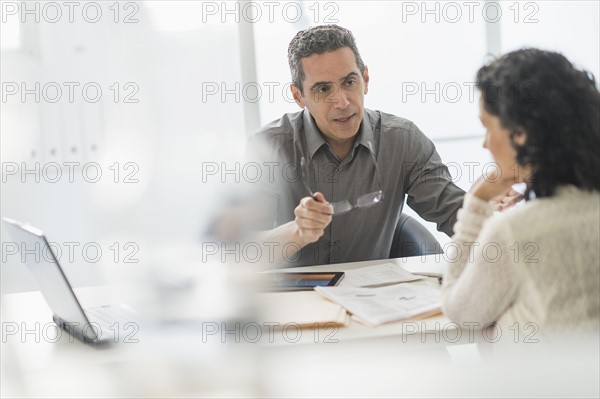 Business people talking at desk in office.