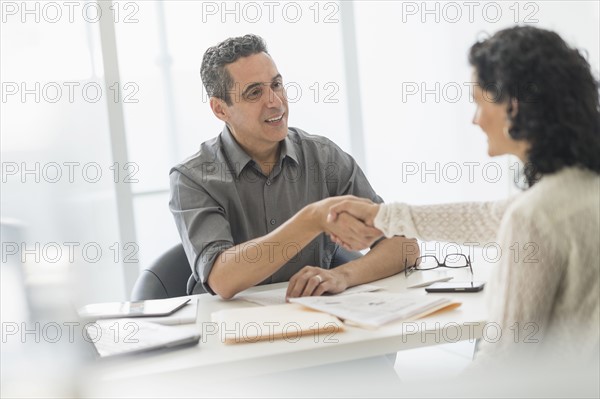 Business people talking at desk in office.