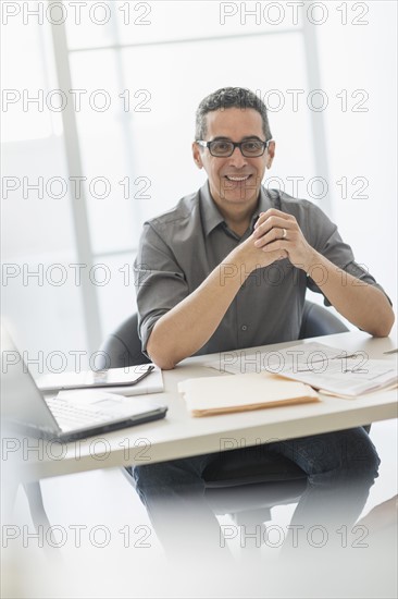 Portrait of man at desk in office.