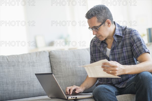 Man doing home finances with laptop.