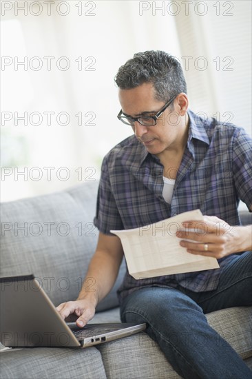 Man doing home finances with laptop.