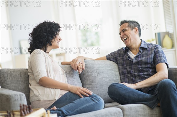 Couple talking on sofa.