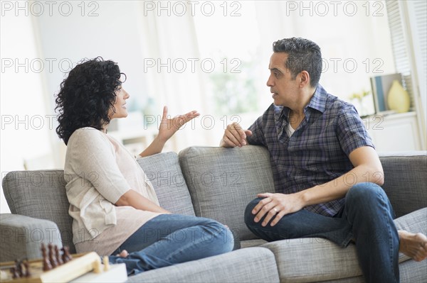 Couple talking on sofa.