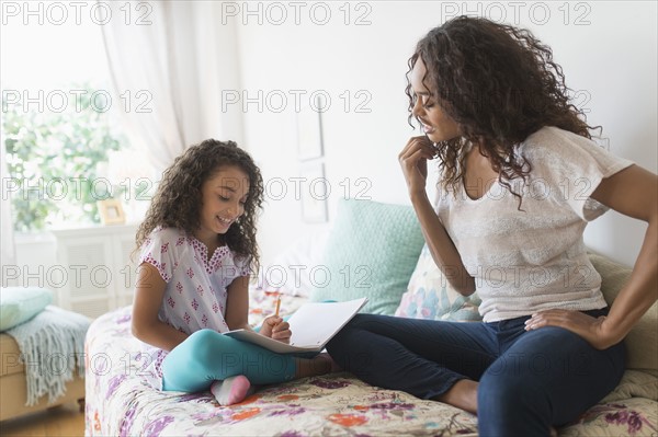 Mother and daughter (8-9) studying together.