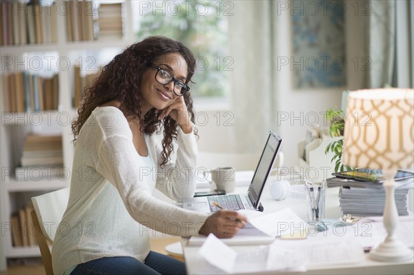 Woman using laptop in home office.