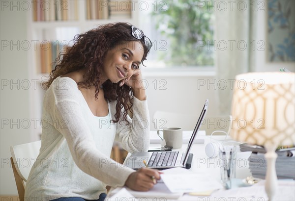 Woman using laptop in home office.