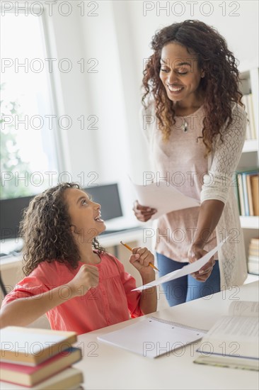 Girl (8-9) receiving test result in classroom.