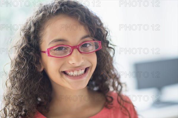 Portrait of schoolgirl (8-9) wearing pink eyeglasses.