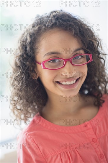 Portrait of schoolgirl (8-9) wearing pink eyeglasses.