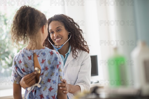 Female doctor examining girl (8-9).