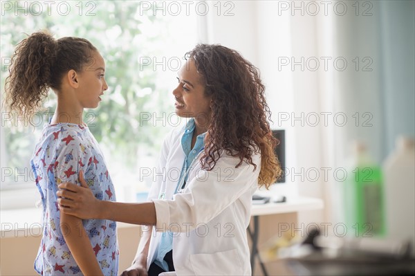 Female doctor examining girl (8-9).