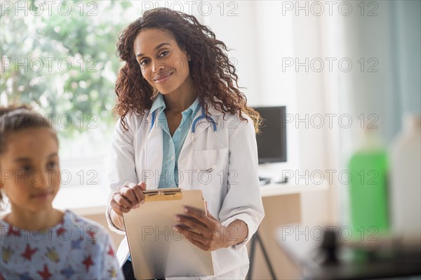 Female doctor examining girl (8-9).