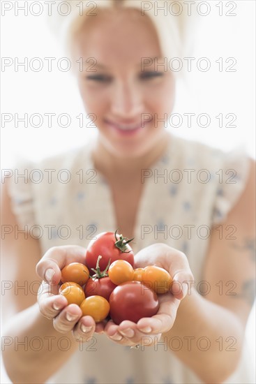 Woman holding tomatoes.