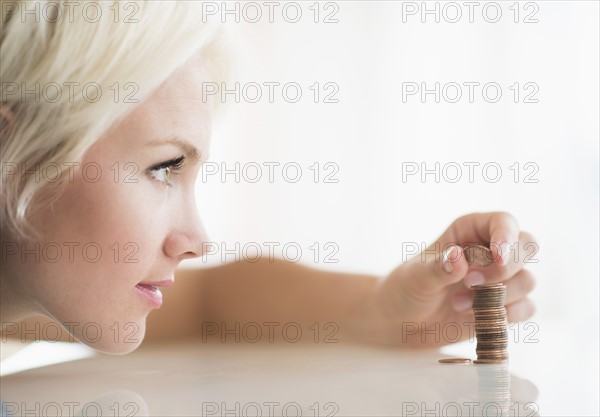 Close-up of woman stacking coins.