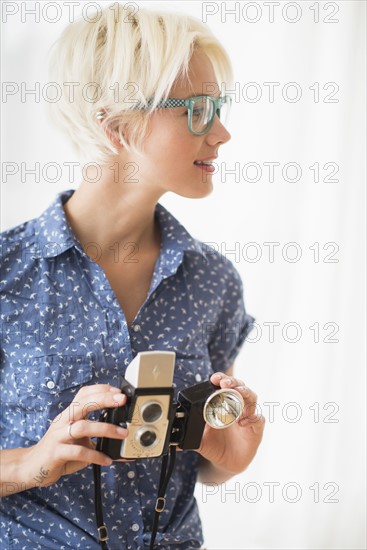 Woman holding vintage camera.