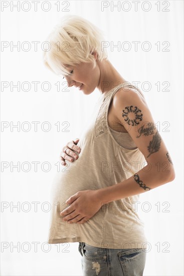 Pregnant woman with hands on stomach.