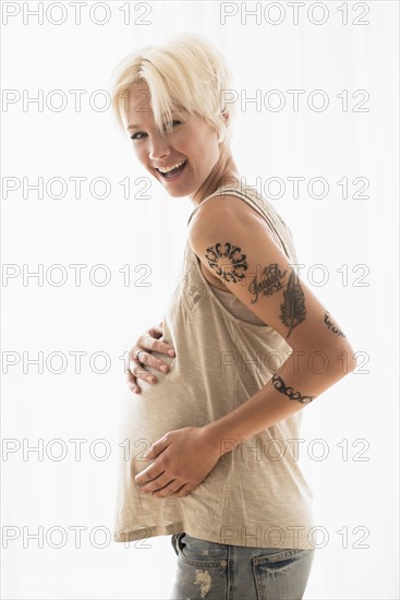 Pregnant woman with hands on stomach.