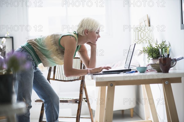 Woman using laptop and at home.