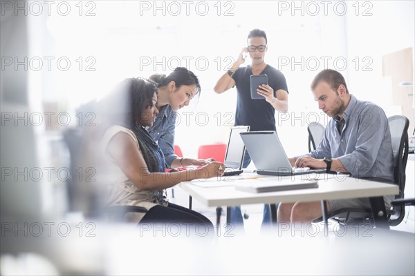 Women and men working in office.